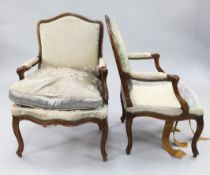 A pair of Louis XV provincial French beech framed fauteuils, with brass studded silk damask