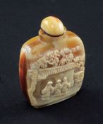 A Chinese hornbill snuff bottle, early 20th century, carved in relief with figures by a pavilion