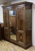 An Edwardian mahogany satinwood crossbanded triple wardrobe, with central mirrored door between