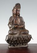 A Chinese bronze seated figure of Guanyin, with separate stand, with gilt lacquered decoration to