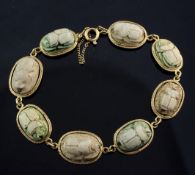 An 18ct gold and Egyptian faience scarab bracelet, set with eight scarabs with carved