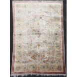 A Persian silk rug, with field of scrolling foliage, on a beige ground with narrow three row border,