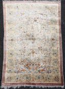 A Persian silk rug, with field of scrolling foliage, on a beige ground with narrow three row border,