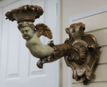 A pair of 19th century Italian carved and painted parcel gilt wall scones, each modelled as a winged