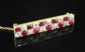 A 1940's/1950's gold, ruby and diamond bar brooch, set with twenty alternating old cut rubies and