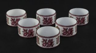 A set of six late 19th century enamel on copper circular napkin rings, decorated with peacocks and