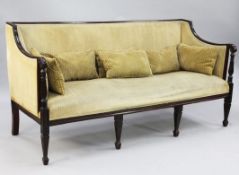 An Edwardian mahogany framed settee, upholstered in a pale yellow fabric, with square tapering