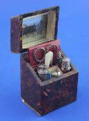 An early 19th century French? tortoiseshell mounted necessaire, the slanted hinged lid opening to