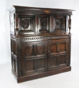 A 17th century carved oak court cupboard, with the date 1611 and initials WW, with cup and cover