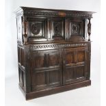 A 17th century carved oak court cupboard, with the date 1611 and initials WW, with cup and cover