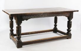 A 17th century style oak refectory table, with single guilloche carved frieze, cup and cover