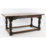 A 17th century style oak refectory table, with single guilloche carved frieze, cup and cover