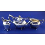 An Edwardian Scottish silver three piece tea set, of oval form, with engraved monogram, cast foliate