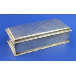 An Edwardian silver mounted cigarette box, of rectangular form, with gadrooned borders, Spink & Son,