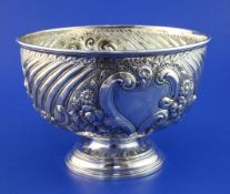 A late Victorian repousse silver rose bowl, with fluted and foliate scroll decoration, on circular