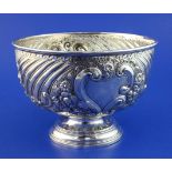 A late Victorian repousse silver rose bowl, with fluted and foliate scroll decoration, on circular