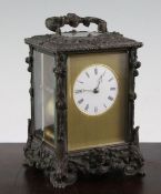 A late 19th century bronze carriage clock, with unusual foliate scroll cast case, and enamelled dial
