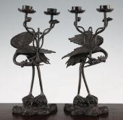 A pair of Japanese 'crane' candelabra, late 19th century, each modelled as a crane holding a sprig