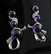 A pair of white gold, amethyst and diamond drop earrings, of scrolling form, set with three