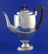 An Edwardian demi-fluted silver pedestal coffee pot, by Walker & Hall, of oval form, with ebonised