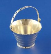 A George III silver cream pail by William Plummer, with ribbed body and pierced swing handle,