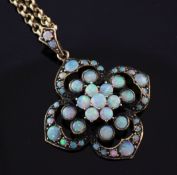 An early 20th century gold and white opal cluster pendant on a later 9ct gold chain, the pendant