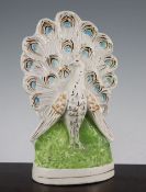 An unusual Staffordshire pottery flatback peacock figure, mid 19th century, the plumage of the
