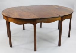 A 19th century mahogany extending dining table, with single extra leaf and two demi-lune ends,