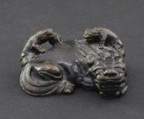 A Chinese bronze scroll weight, 19th century, cast in the form of a lion-dog and two cubs clambering