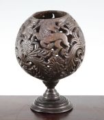 A 19th century carved and pierced coconut cup or goblet, decorated with owls, birds and vases of