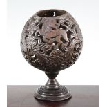A 19th century carved and pierced coconut cup or goblet, decorated with owls, birds and vases of
