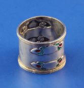 An Edwardian Art Nouveau Liberty & Co Cymric silver and enamel napkin ring, embossed with four two
