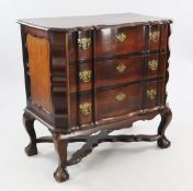 A South African stinkwood Dutch colonial style serpentine chest, of three long drawers, on