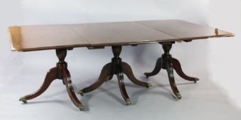 An early 19th century mahogany triple pillar extending dining table, with two extra leaves, with