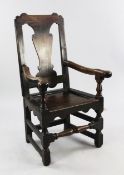 An 18th century oak open armchair, with vase shaped splat, panel seat and baluster turned foot rail