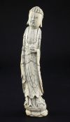 A Chinese ivory tusk carving of Buddha, Qing dynasty, the elongated figure holding a peach in his