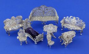 A small group of silver filigree miniature furniture, comprising three settees, two occasional