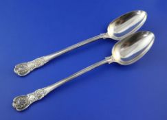 A matched pair of Victorian silver double struck scroll rosette pattern basting spoons, with