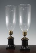 A pair of marble based storm lamps, 19.5in. A pair of marble based storm lamps, with glass shades,