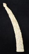 An early 20th century Belgian Congo carved ivory oliphant, carved with a spiralling procession of