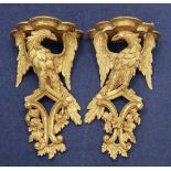 A pair of 18th century carved giltwood wall brackets, each modelled as an eagle with outstretched