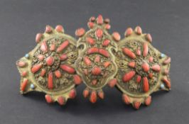 A 19th century Turkish bronzed metal two piece belt buckle, with filigree decoration, set with coral