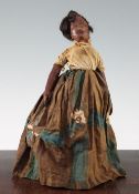 An antique leather black doll, c.1850, in traditional costume, (possibly Martinique in origin)