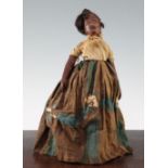 An antique leather black doll, c.1850, in traditional costume, (possibly Martinique in origin)