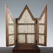 An early 20th century hardwood folding triptych, mounted with ten carved ivory panels depicting