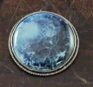 A Ruskin pottery silver mounted brooch, the slightly domed circular plaque decorated in blue, pale