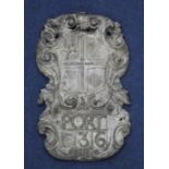 A late 17th century cartouche shape armorial wall plaque, modelled as quartered shield with sword to