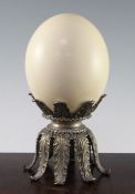 Manner of Redmile. An ostrich egg, with a plated brass acanthus leaf cast base, unsigned, 9.75in.