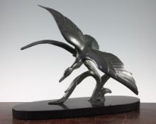 A French Art Deco patinated bronze model of a duck in flight, on oval black marble base, signed Tit,