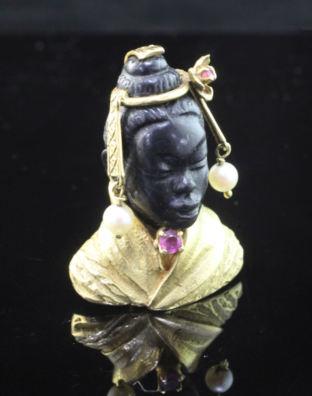 A 20th century 18ct gold, ruby, carved obsidian? and cultured pearl brooch modelled as the bust of